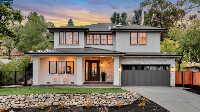 a front view of a house with a yard and potted plants