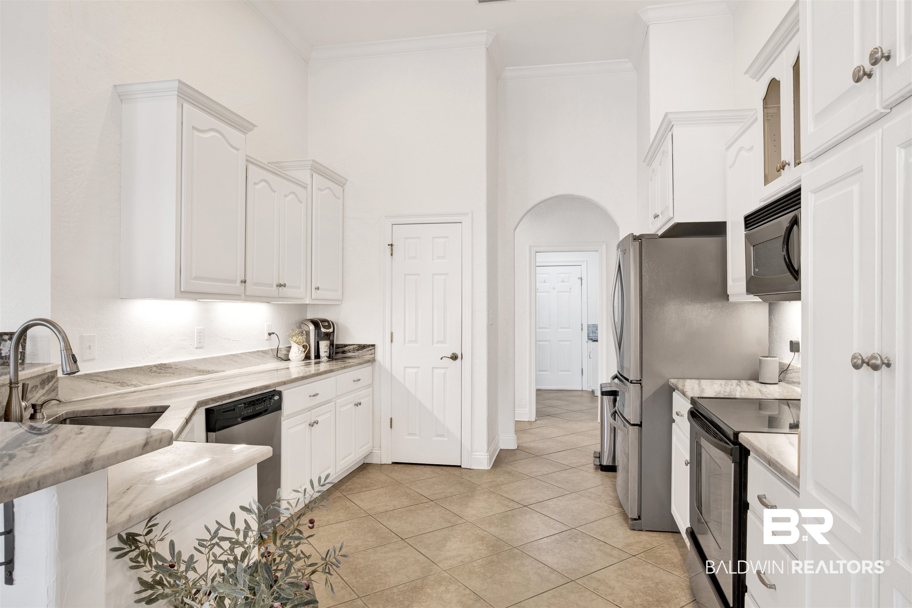 31295 River Road Orange Beach, AL 36561 - Photo 3 of 58 Kitchen featuring white cabinets, light tile patterned floors, sink, and black appliances