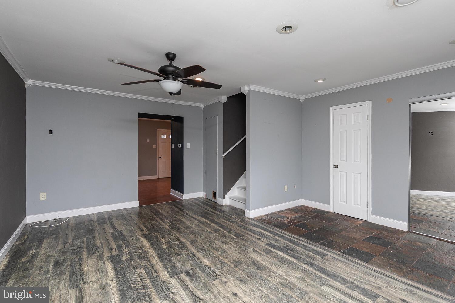 a view of empty room with wooden floor and ceiling fan