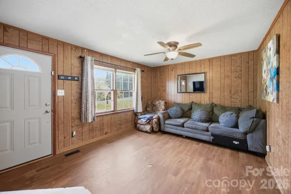 a view of a hallway with wooden floor and furniture