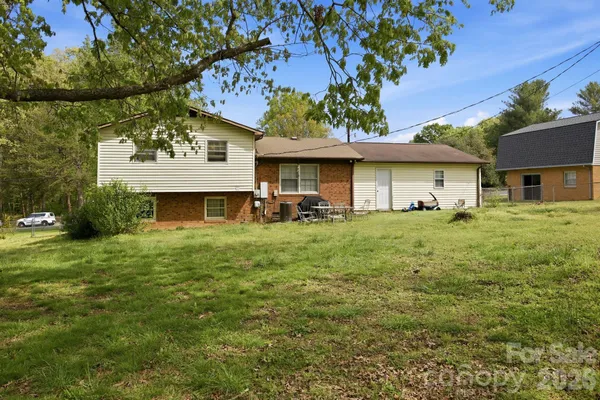 a view of a yard in front of a house with large tree