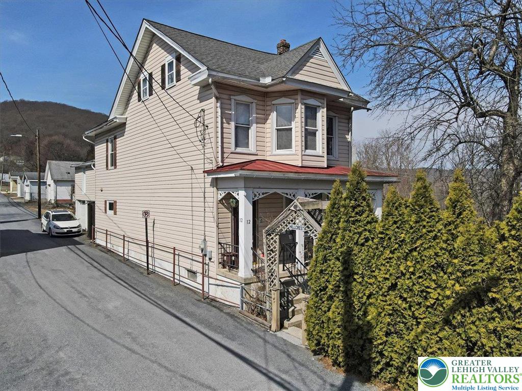 12 Chestnut Avenue Jim Thorpe, PA 18229 - Photo 1 of 38 a view of a white house with large windows and a small yard