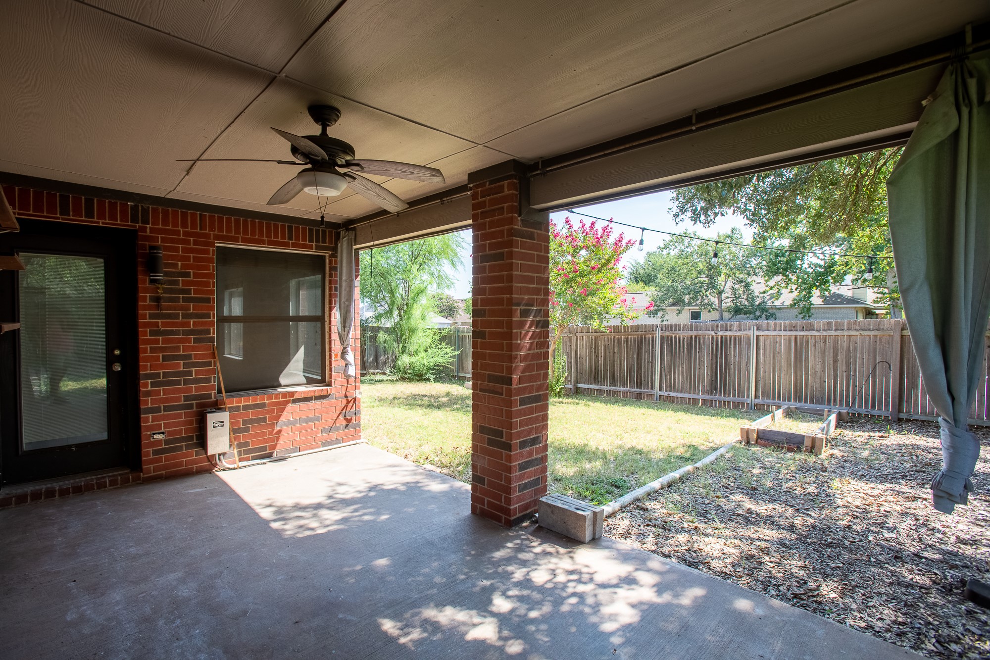 1201 Springbrook Road Pflugerville, TX 78660 - Photo 30 of 33 An inviting covered patio offers a comfortable outdoor living space with direct access to a private, fenced backyard.