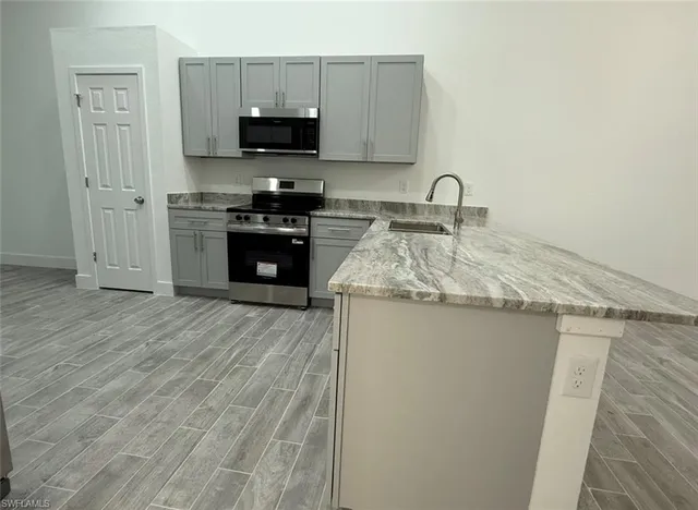 a kitchen with granite countertop a stove top oven and sink