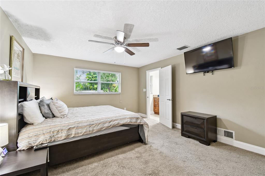 1948 Belleair Road Clearwater, FL 33764 - Photo 23 of 84 a bedroom with a bed a tv and wooden floor