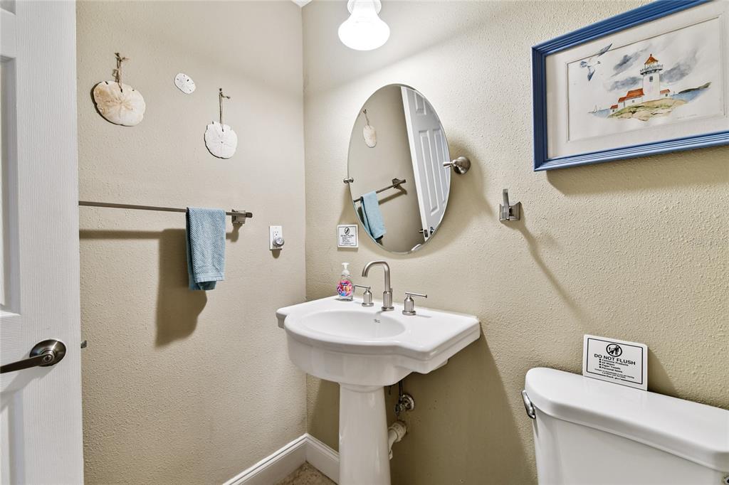1948 Belleair Road Clearwater, FL 33764 - Photo 36 of 84 a bathroom with a sink a toilet and mirror