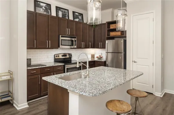 a kitchen with stainless steel appliances granite countertop a sink refrigerator and microwave