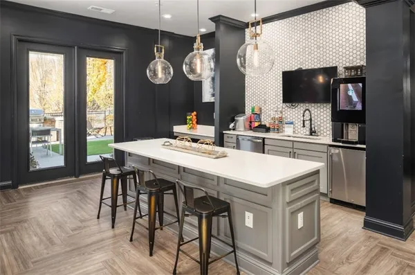 a kitchen with a table chairs and a flat screen tv