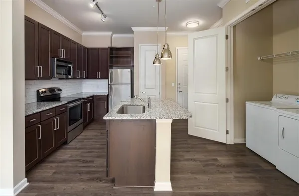 a kitchen with stainless steel appliances granite countertop a refrigerator a stove and a sink