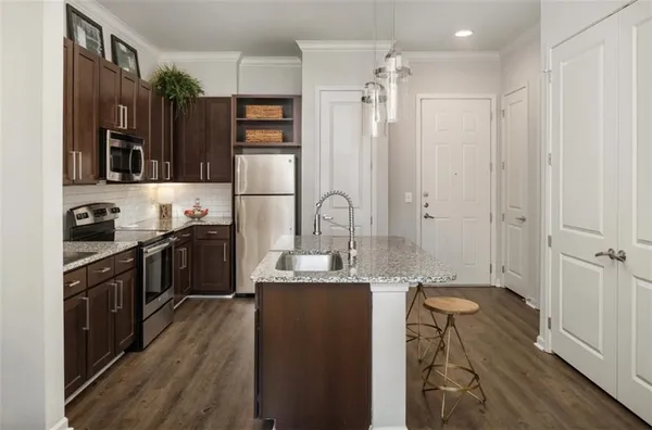 a kitchen with kitchen island granite countertop a sink stove and refrigerator