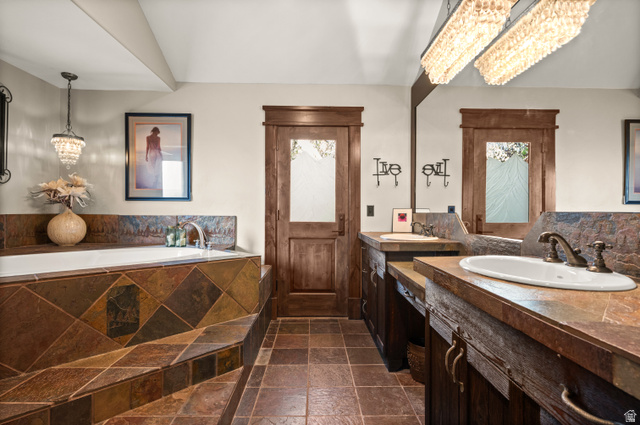 10280 Dimple Dell Road Sandy, UT 84092 - Photo 33 of 58 Bathroom featuring stone tile flooring, hanging lights, vanity, and a bath