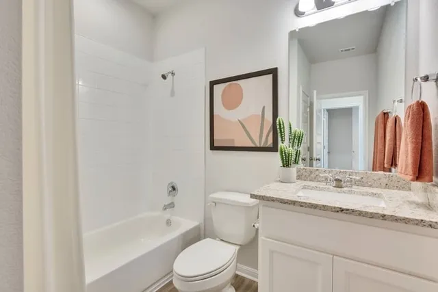 a bedroom with a bed and a lamp on dresser