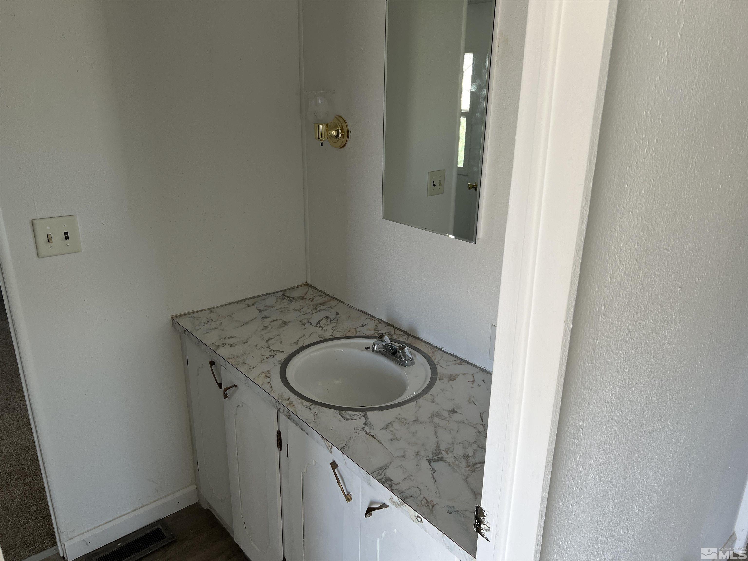1495 Rice Road Fallon, NV 89406 - Photo 4 of 22 a bathroom with a granite countertop sink and a mirror