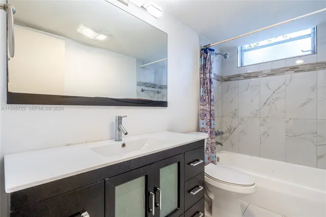 a bathroom with a sink a toilet a mirror and shower