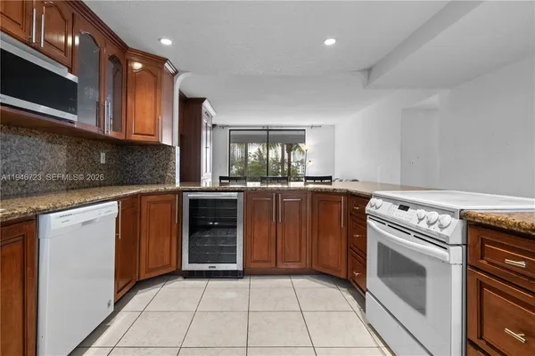 a kitchen with granite countertop a stove top oven microwave and cabinets