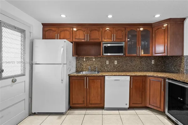 a kitchen with stainless steel appliances granite countertop a refrigerator and a stove top oven