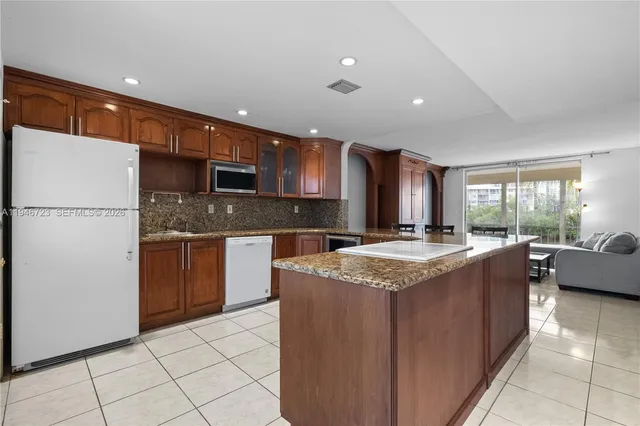 a kitchen with stainless steel appliances granite countertop a stove a sink and a refrigerator