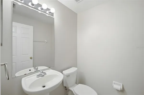 a bathroom with a sink a toilet and mirror