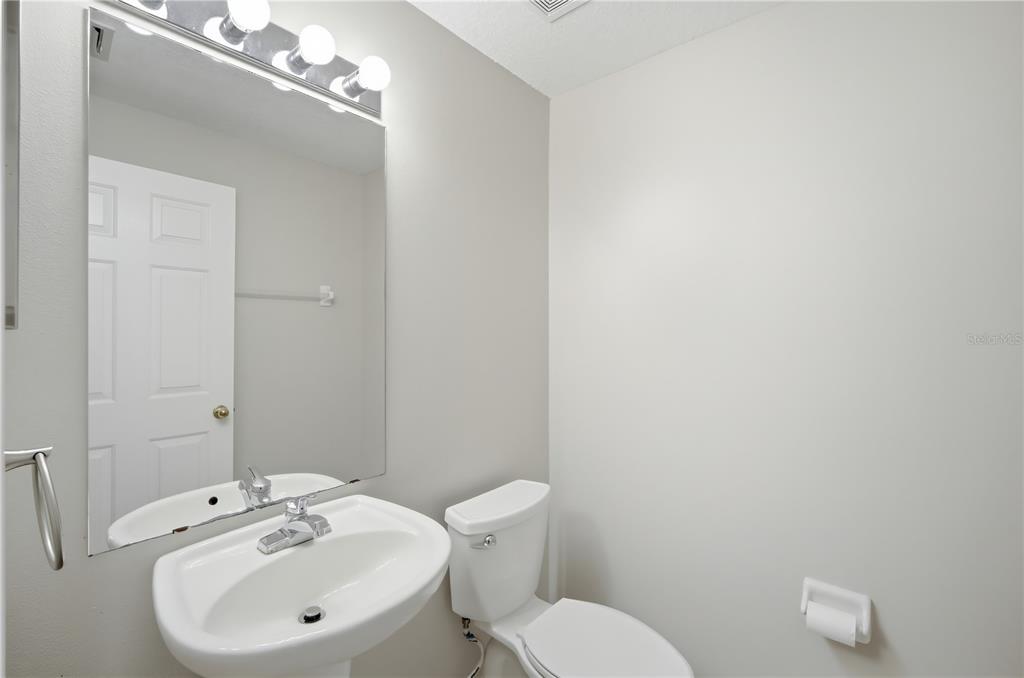 1417 Sedgwick Drive Wesley Chapel, FL 33543 - Photo 4 of 22 a bathroom with a sink a toilet and mirror