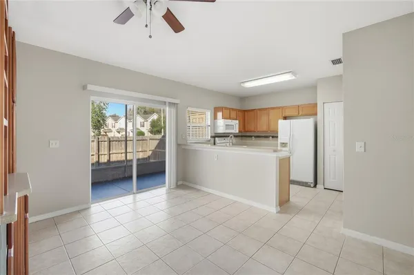 a view of a kitchen with a sink and dishwasher a refrigerator with white cabinets
