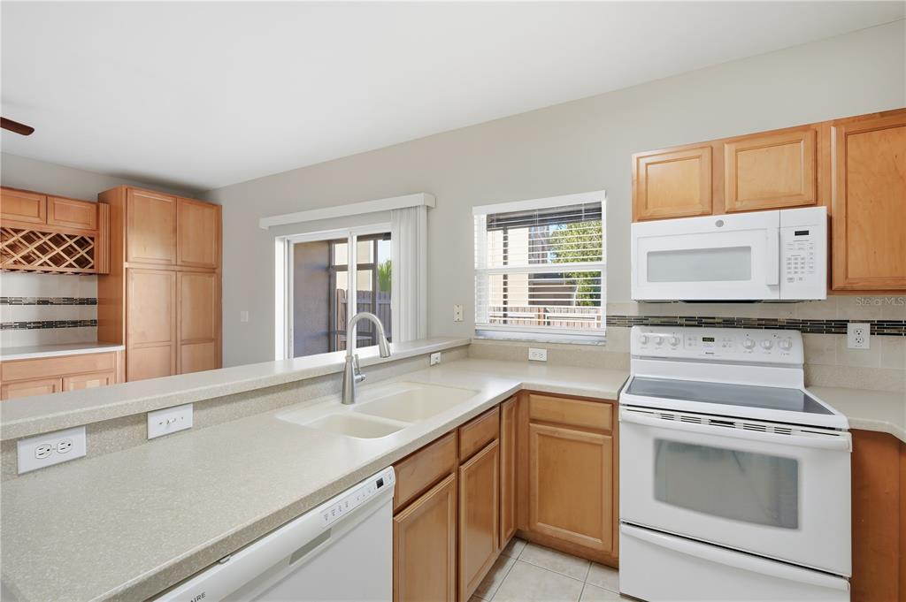 1417 Sedgwick Drive Wesley Chapel, FL 33543 - Photo 10 of 22 a kitchen with granite countertop white cabinets and white appliances