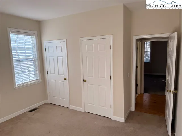 an empty room with windows and closet