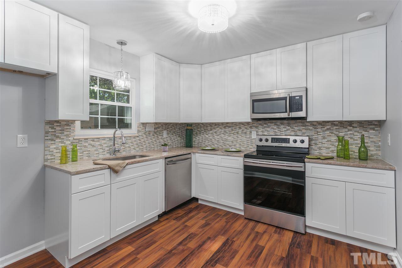 6453 New Market Way, Unit 6453 Raleigh, NC 27615 - Photo 11 of 30 New cabinets, stainless steel appliances, granite and backsplash make this kitchen a delightful place to prepare dinners!