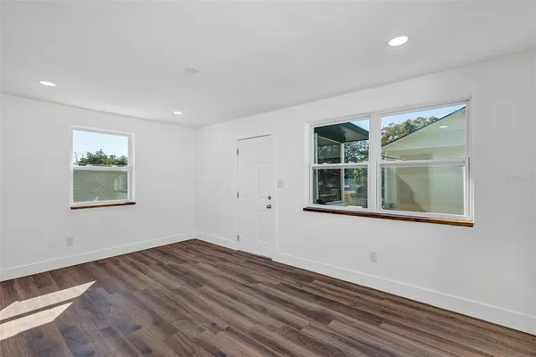 a view of empty room with wooden floor