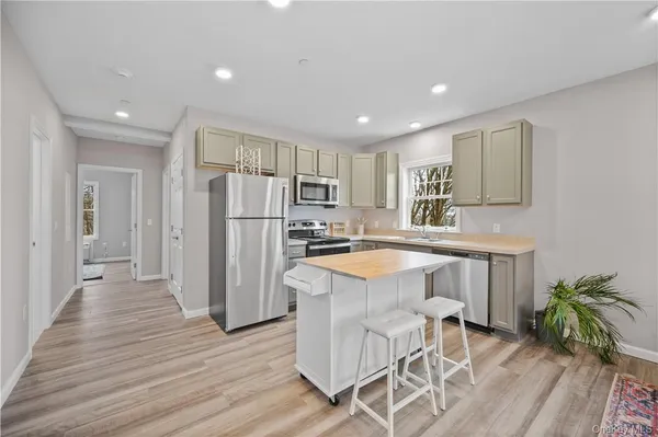a kitchen with granite countertop white cabinets and stainless steel appliances