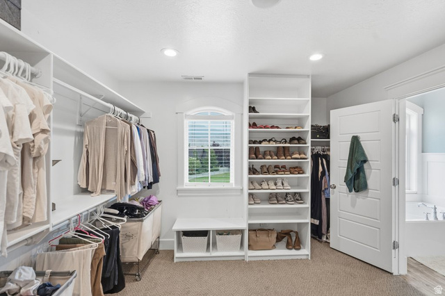 672 Perry Hollow Drive Mapleton, UT 84664 - Photo 49 of 106 Primary bdm, Expansive walk-in closet featuring built-in shelving, hanging rods, and a window with natural light