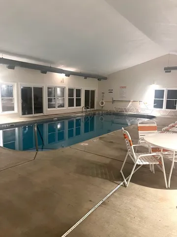 a view of a house with pool and sitting area
