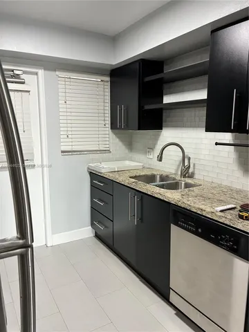 a kitchen with granite countertop a sink and a stove