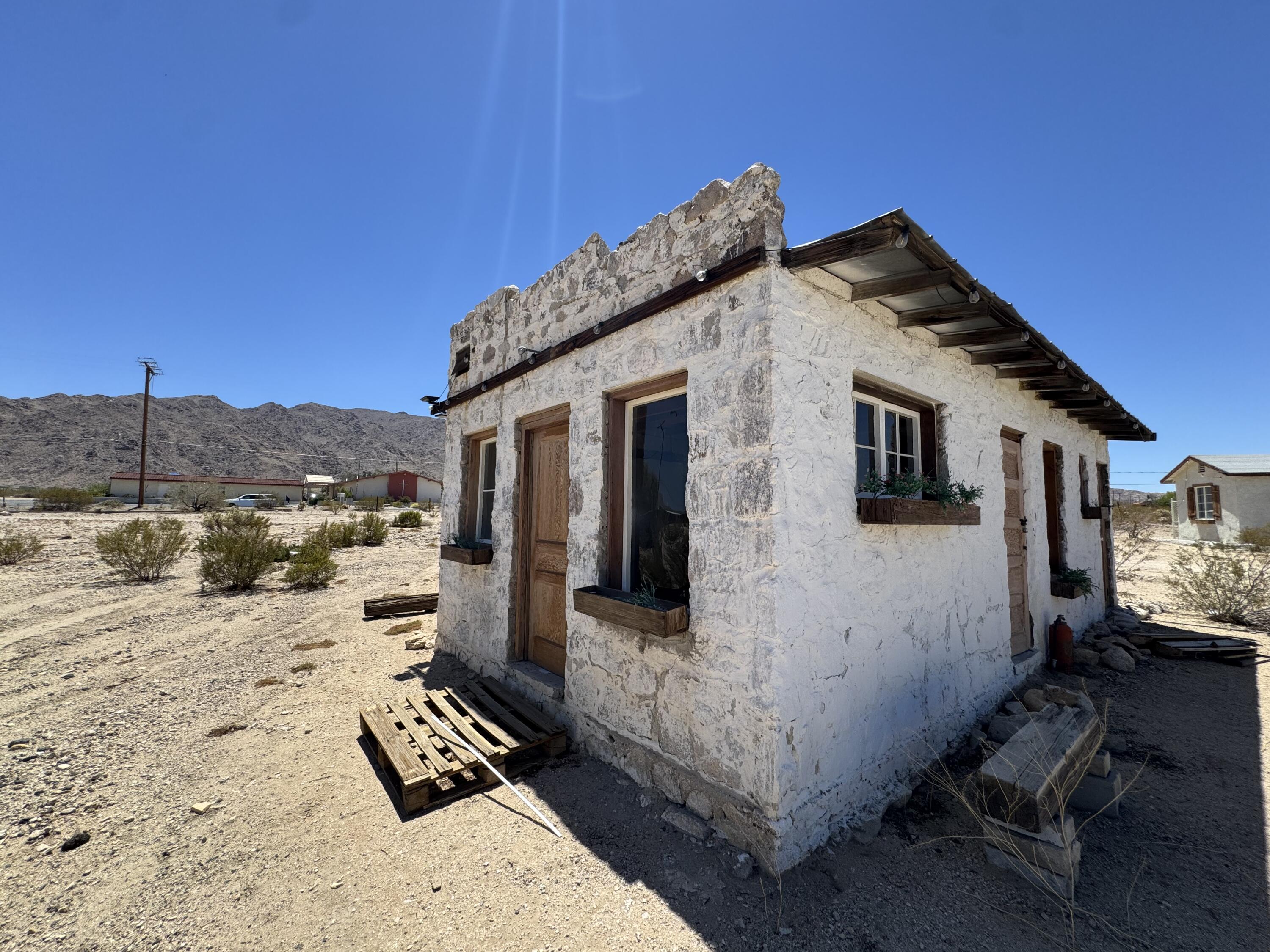 73392 Sullivan Road Twentynine Palms, CA 92277 - Photo 14 of 29 a view of a white house with wooden fence