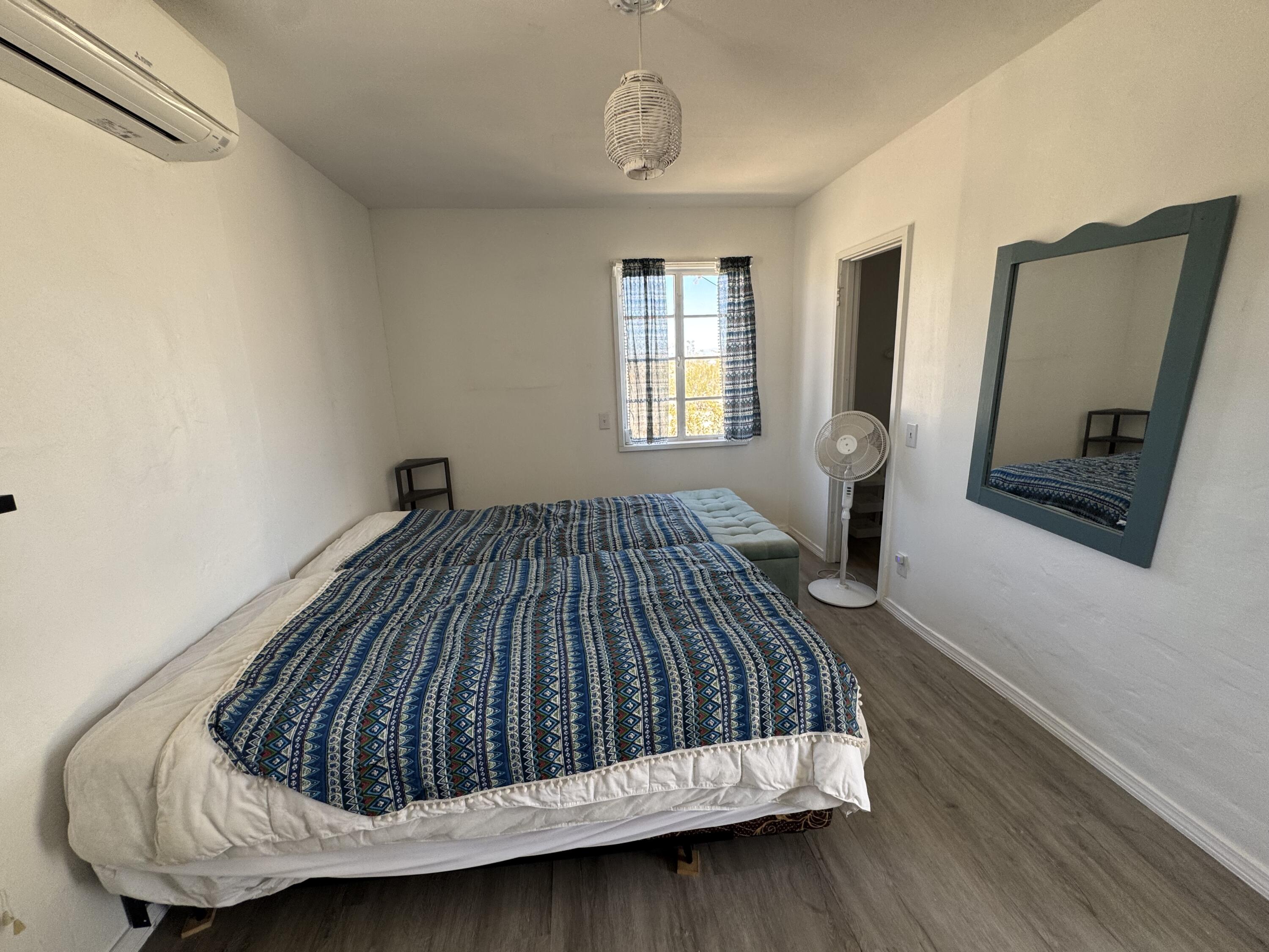 73392 Sullivan Road Twentynine Palms, CA 92277 - Photo 22 of 29 a view of bedroom with a bed and wooden floor