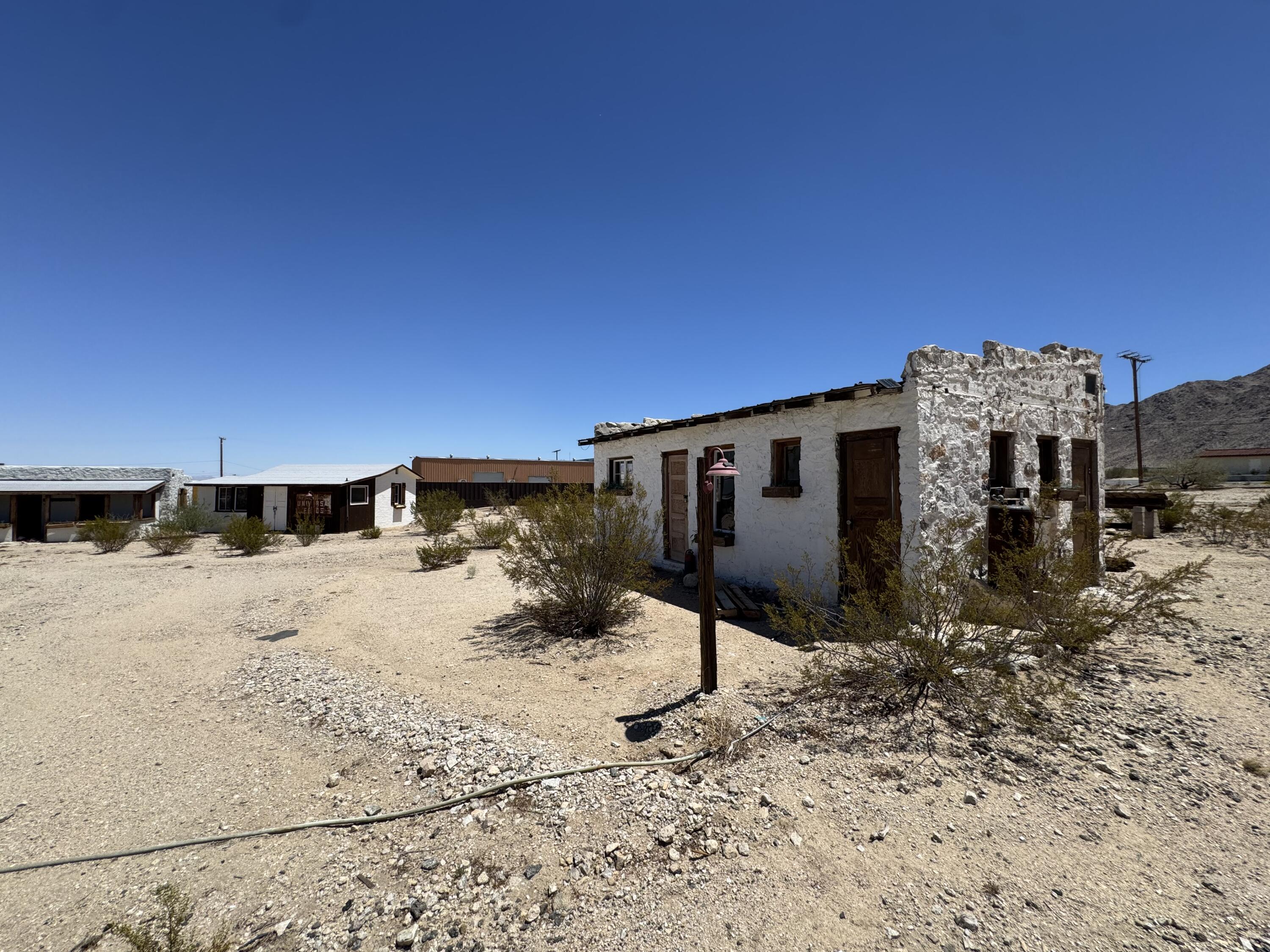 73392 Sullivan Road Twentynine Palms, CA 92277 - Photo 5 of 29 a backyard of a house with a table and chairs under an umbrella