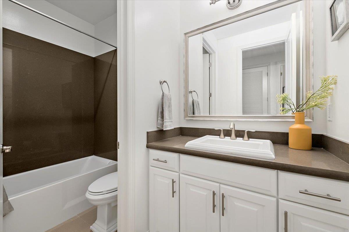 3003 Marcelli Circle Los Altos, CA 94022 - Photo 12 of 21 a bathroom with a granite countertop sink a toilet a mirror and shower