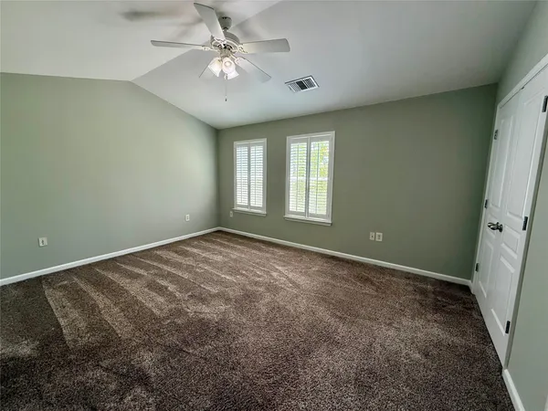 an empty room with windows and fan