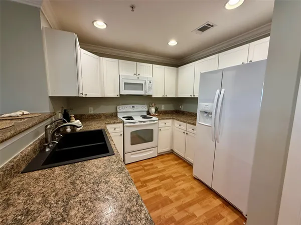 a kitchen with a white stove top oven and white cabinets