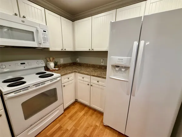 a kitchen with stainless steel appliances white cabinets and white appliances