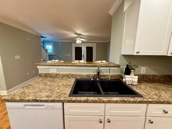 a kitchen with granite countertop a sink a stove and cabinets