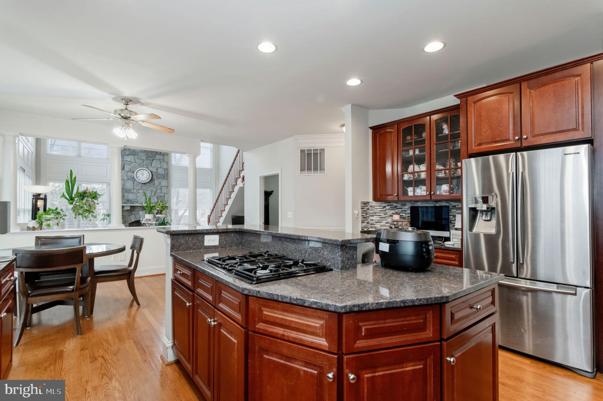 11375 Harding Road Laurel, MD 20723 - Photo 12 of 40 a kitchen with stainless steel appliances granite countertop a stove refrigerator and a dining table with wooden floor