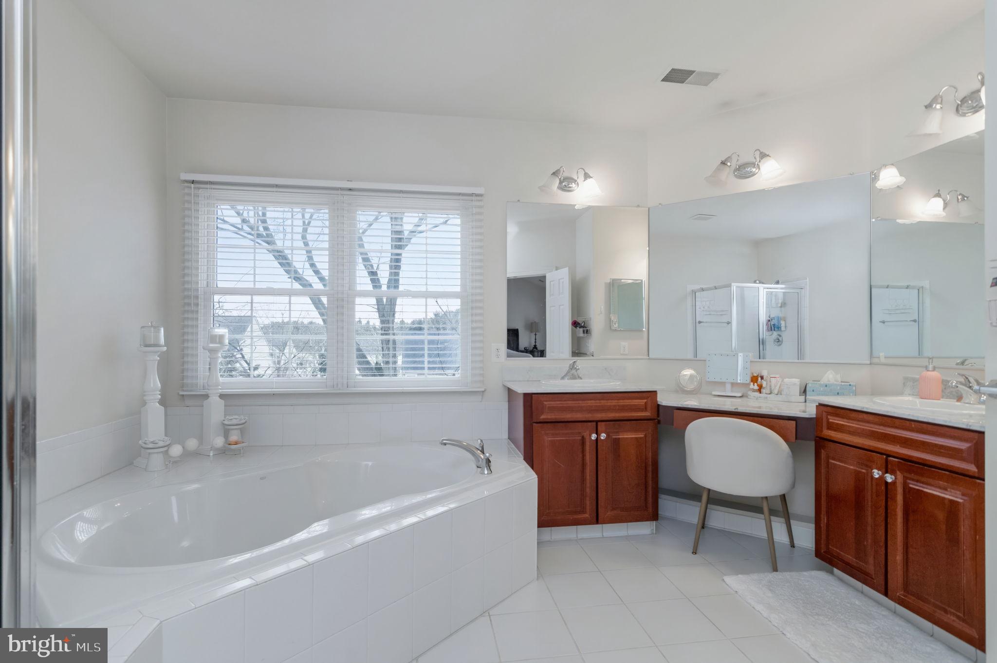 11375 Harding Road Laurel, MD 20723 - Photo 22 of 40 a large spacious bathroom with a granite countertop tub sink and mirror