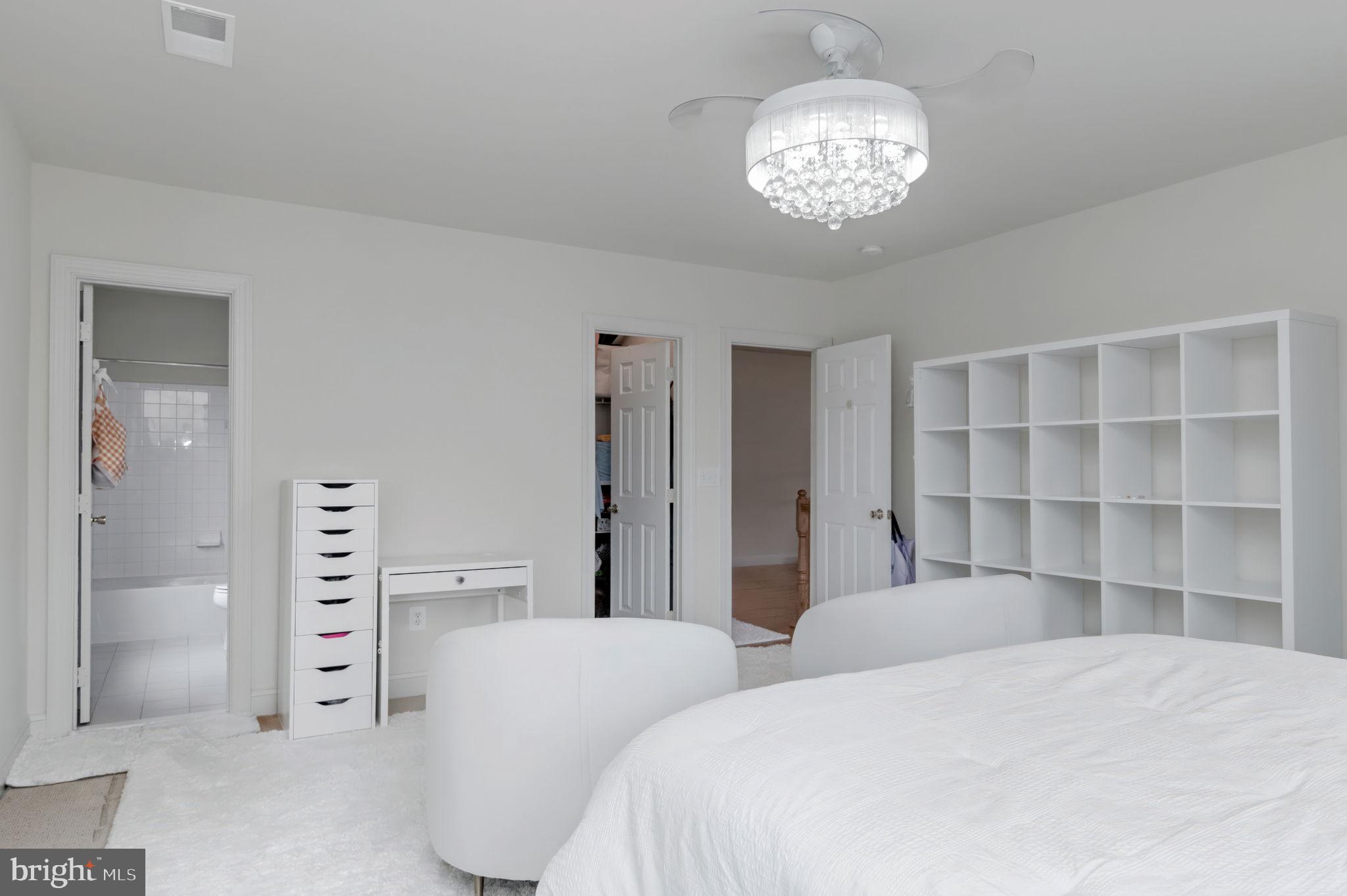 11375 Harding Road Laurel, MD 20723 - Photo 25 of 40 a bedroom with a large bed and a chandelier