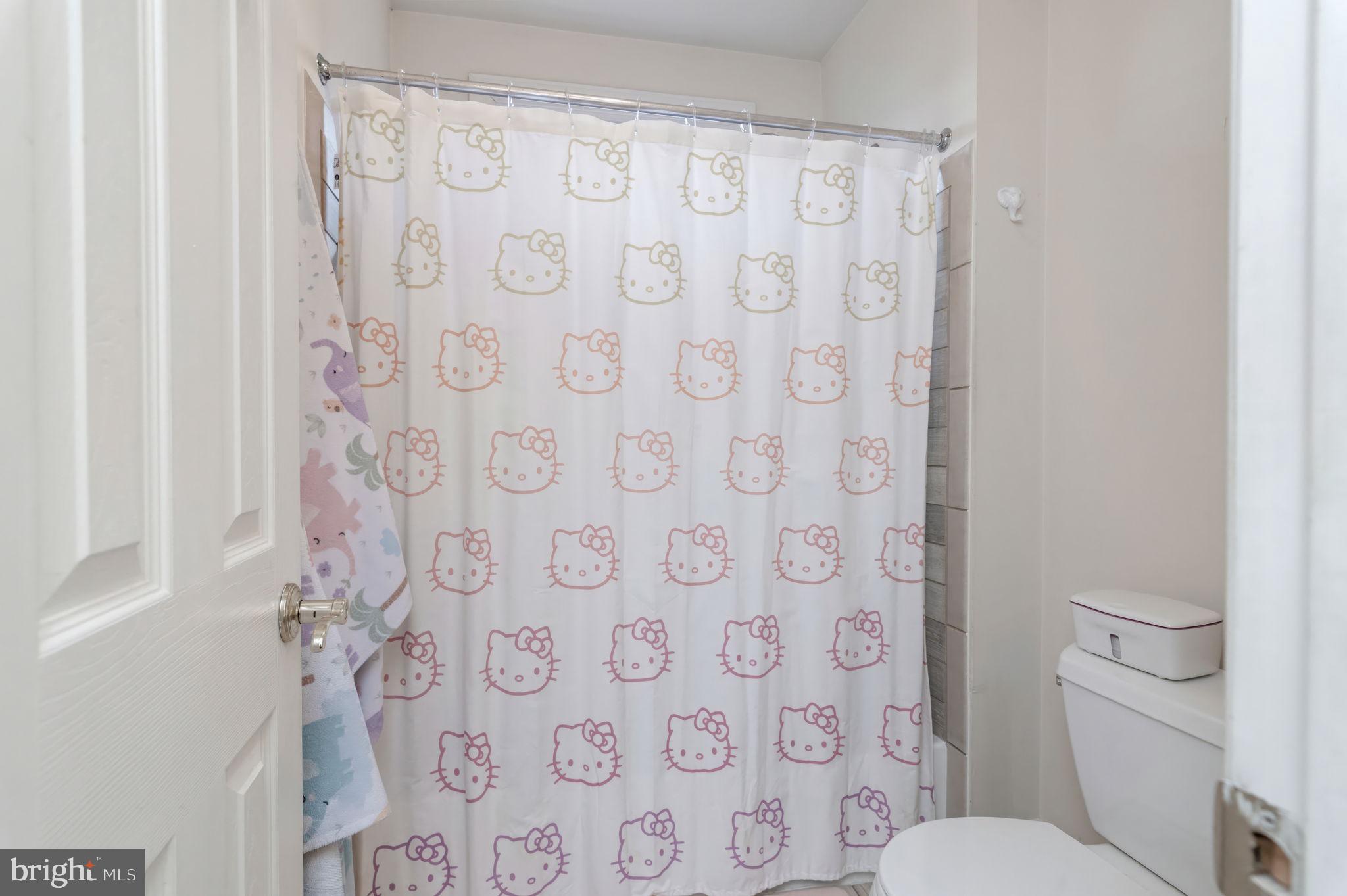 11375 Harding Road Laurel, MD 20723 - Photo 31 of 40 a white toilet sitting next to a shower curtain