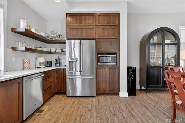a kitchen with stainless steel appliances a refrigerator and wooden floor