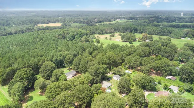 an aerial view of a houses with a yard and lake view