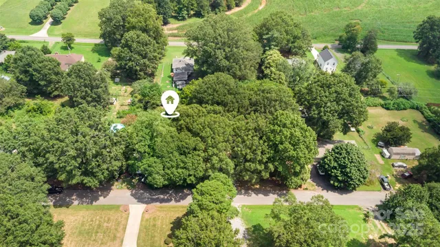 an aerial view of residential house with outdoor space and trees all around