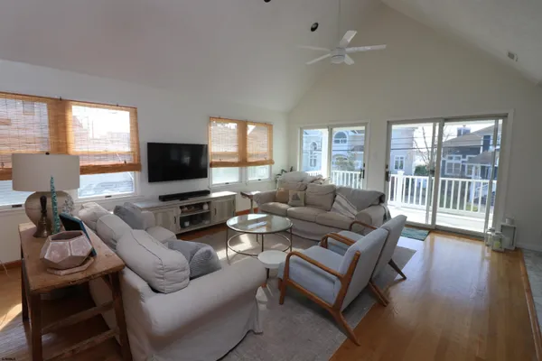 a living room with furniture a flat screen tv and a large window