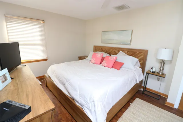 a bedroom with a bed and wooden floor