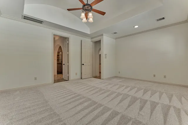 a view of an empty room with a chandelier fan
